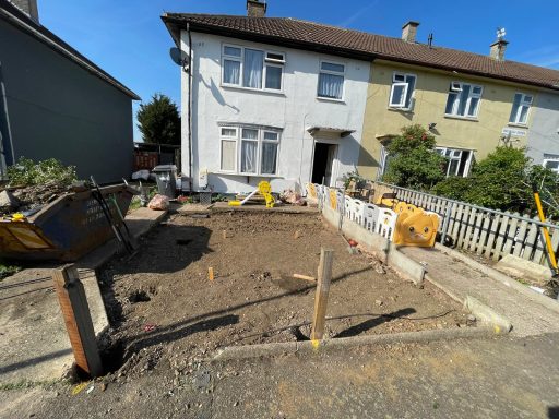 Front garden of a house under a state of repair. Bare soil on the front and edging stones ready for a fence.